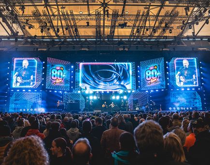 Große Konzertbühne mit LED-Wänden und Liveband vor vollem Publikum bei „80er Live“