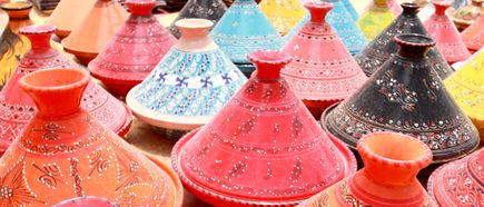 Verschiedene bunte Keramik-Tajine-Töpfe mit dekorativen Mustern, dicht nebeneinander angeordnet