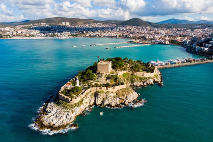 Luftaufnahme der Insel Güvercinada in Kusadasi mit historischem Kastell, Leuchtturm und der angrenzenden Hafenpromenade