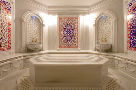 Traditioneller Hamam-Bereich mit Marmorflächen, warmem Licht und orientalischen Details