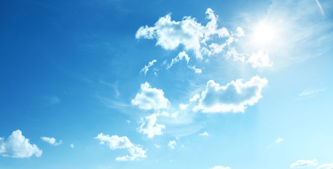 Blauer Himmel mit vereinzelten weißen Wolken und Sonnenlicht