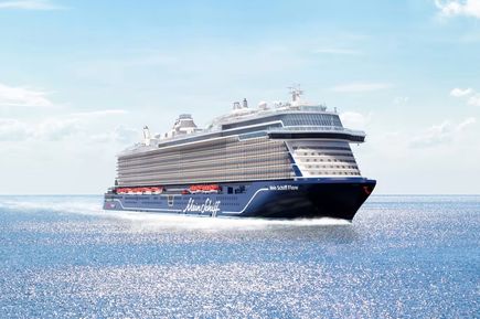 Das Kreuzfahrtschiff „Mein Schiff Flow“ gleitet bei sonnigem Wetter über das ruhige Meer, während sich das Licht glitzernd auf der Wasseroberfläche spiegelt