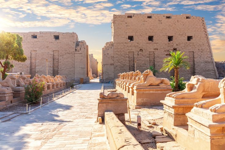 Der Karnak-Tempel in Luxor zeigt eine monumentale Tempelallee mit Sphinx-Statuen, die zu den gewaltigen Pylonen aus Sandstein führen