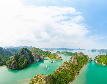 Luftaufnahme der Halong-Bucht in Vietnam mit zahlreichen bewaldeten Kalksteininseln und türkisfarbenem Wasser