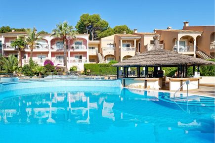  Poolanlage des R2 Lago Playa Park mit türkisblauem Swimmingpool, überdachter Poolbar und Apartmentgebäuden Stil im Hintergrund.