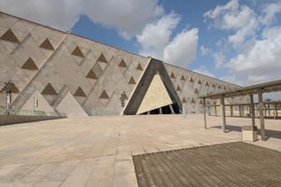 Modernes Gebäude des Ägyptischen Museums mit dreieckigem Eingang und geometrischen Mustern an der Fassade unter bewölktem Himmel