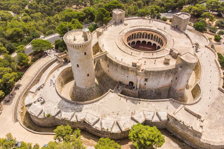 Luftaufnahme des Castell de Bellver in Palma de Mallorca, runde Festungsanlage mit Türmen und Innenhof, umgeben von Pinienwald