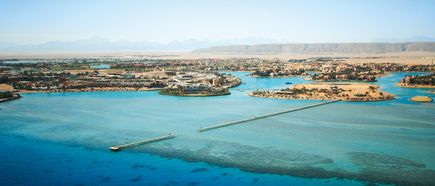 Luftaufnahme von El Gouna mit Wasserwegen, Brücken und Gebäuden vor einer Berglandschaft