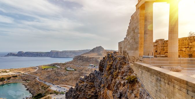 Antike Säulenruine auf einem Felsen mit Blick auf Küste und Meer bei Sonnenuntergang auf Rhodos