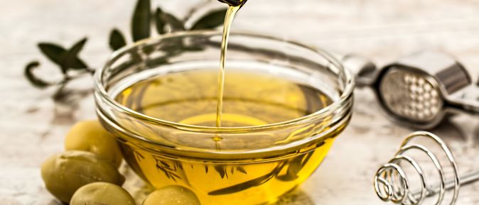 Schale aus Glas wird mit Olivenöl befüllt