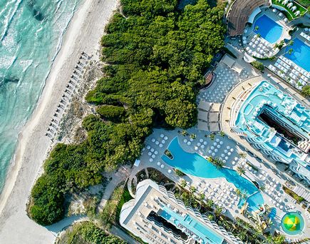 Luftaufnahme des Iberostar Selection Albufera Park mit großem Pool, direktem Zugang zum weißen Sandstrand und dichter grüner Vegetation auf Mallorca
