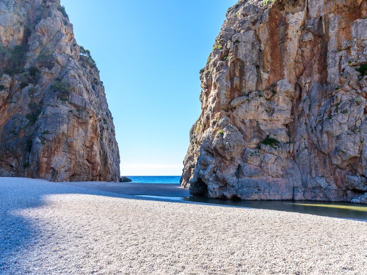 Kiesstrand Torrent de Pareis zwischen zwei steilen Felsen mit Blick auf das Meer