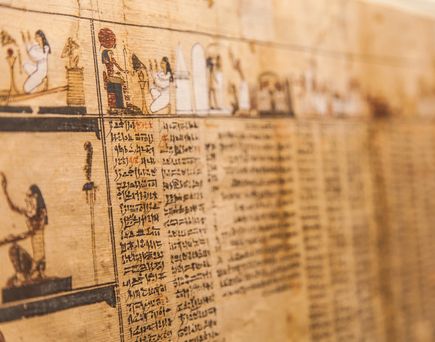 Detailaufnahme eines antiken ägyptischen Papyrus mit Hieroglyphen und Abbildungen von Figuren und Szenen