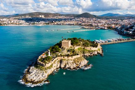 Panoramablick auf die Halbinsel Güvercinada in Kuşadası mit historischer Festung, Leuchtturm und dem umliegenden azurblauen Meer