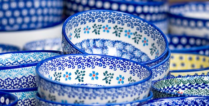 Mehrere ineinander gestapelte Keramikschalen mit blau-weißen und gelb-blauen floralen Mustern.