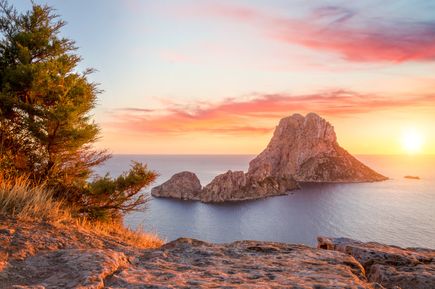 Felseninsel Es Vedrà vor der Küste Ibizas im Sonnenuntergang mit Blick aufs Meer