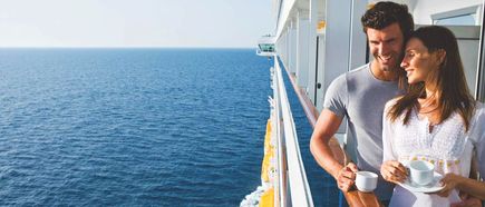 Ein Mann und eine Frau stehen auf dem Balkon einer Kabine der Costa Diadema und genießen Kaffee mit Blick aufs offene Meer