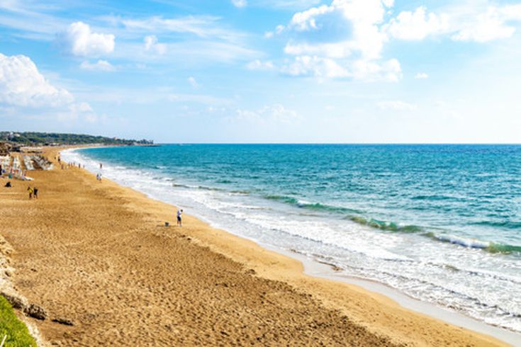 Breiter Sandstrand in Side an der türkischen Riviera mit klarem, blauem Meer, Sonnenschirmen und Liegen