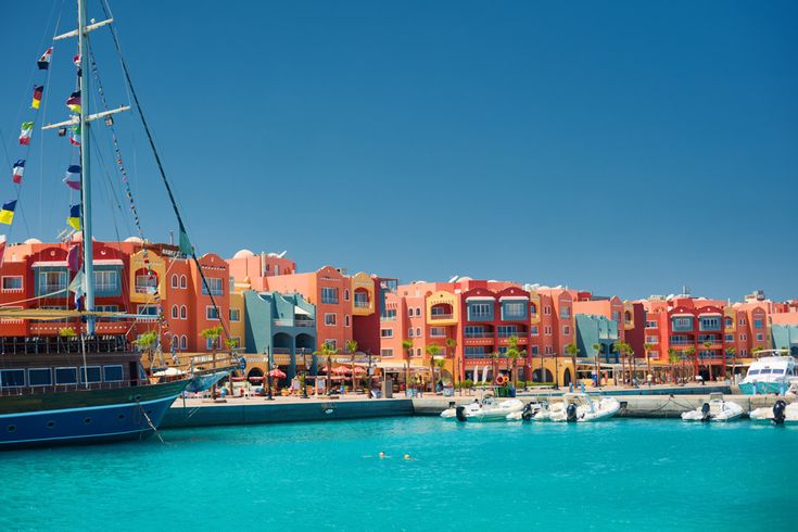 Bunte Häuserfassaden und Hafenpromenade in der Marina von Hurghada mit Segelbooten und Yachten