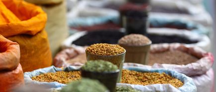 Säcke mit Gewürzen auf einem Markt, vorne verschiedene Sorten in Gläsern