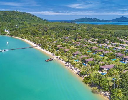 Luftaufnahme der tropischen Resortanlage des Barcelò Coconut Island an einer türkisfarbenen Bucht mit langen Sandstränden, dichtem Palmengrün, privaten Villen mit Pools sowie bewaldeten Hügeln