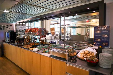 Buffetbereich der Albrecht-Dürer-Lounge am Flughafen Nürnberg mit einer Auswahl an Brötchen, Snacks, Getränken und Sitzbereichen für Reisende