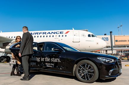 VIP-Service am Flughafen Hamburg mit Abholung direkt am Flugzeug: Reisende steigen neben einem Air-France-Flugzeug in eine Limousine von Mercedes-Benz Hamburg ein