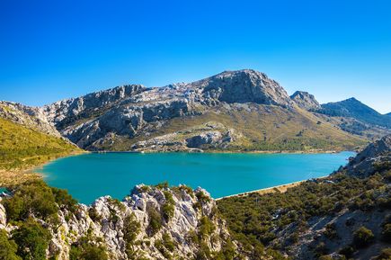 Blick auf den türkisblauen Cúber-Stausee, umgeben von Bergen im Tramuntana-Gebirge auf Mallorca