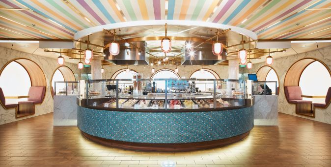 Die Gelateria Amarillo auf der Costa Smeralda mit bunter Deckengestaltung, großer runder Eistheke und gemütlichen Sitzecken im italienischen Stil