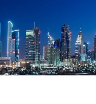 Nächtliche Skyline von Dubai mit beleuchteten Wolkenkratzern, darunter das Hotel Conrad Dubai mit sichtbarem Schriftzug.