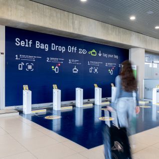 Self Bag Drop Off Bereich im Terminal des Flughafens Köln/Bonn mit mehreren automatisierten Gepäckabgabestationen