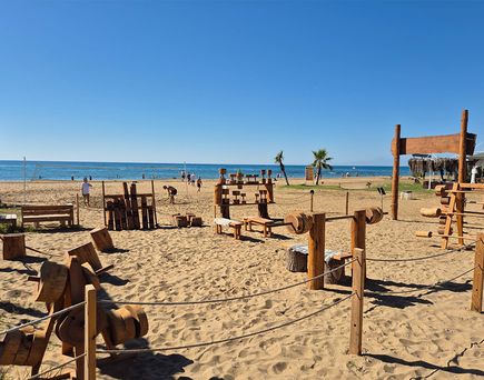 Outdoor-Fitnessgeräte aus Holz auf Sandstrand mit Meer und blauem Himmel im Hintergrund, Armella Hill Hotel & Spa, Türkei.