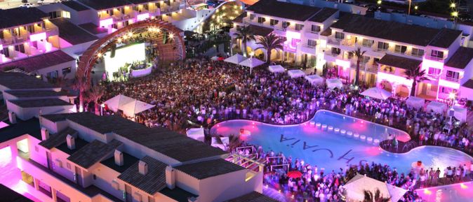 Open-Air-Party im Ushuaïa Ibiza mit DJ-Bühne, Menschenmenge und beleuchtetem Pool bei Nacht