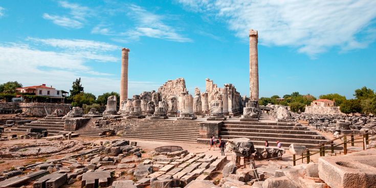Monumentale Ruinen des Apollon-Tempels in Didyma, Türkei, mit hohen Säulen, breiter Treppe und weitläufigem Ausgrabungsfeld unter blauem Himmel