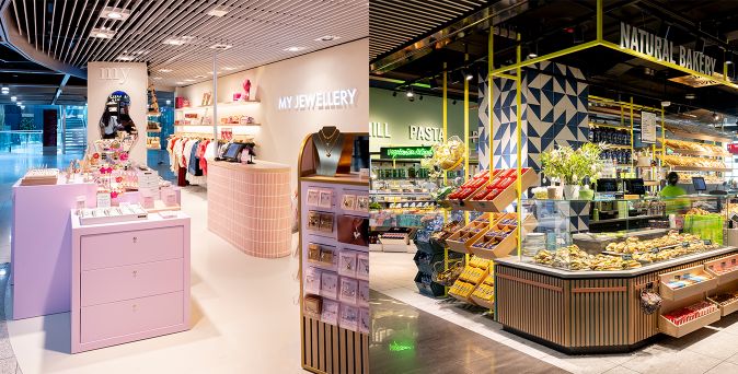 Innenansicht des Düsseldorfer Flughafenterminals mit einem Schmuckladen namens 'MY JEWELLERY' links und einem Bäckerei- und Feinkostbereich mit der Aufschrift 'NATURAL BAKERY' rechts