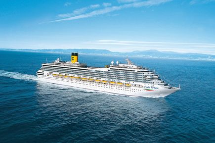 Das Kreuzfahrtschiff Costa Fortuna fährt bei klarem Wetter über das offene Meer, umgeben von blauem Wasser und einer fernen Küstenlinie