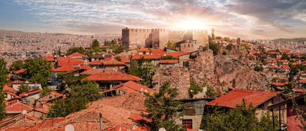 Panorama von Ankara mit der historischen Zitadelle, traditionellen Häusern mit roten Dächern und weiter Stadtlandschaft bei Sonnenuntergang