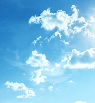 Blauer Himmel mit vereinzelten weißen Wolken und Sonnenlicht