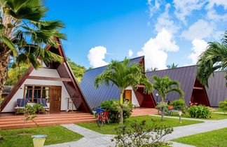 Chalets der La Digue Island Lodge mit markanten, schrägen Dächern, umgeben von Palmen und tropischem Garten