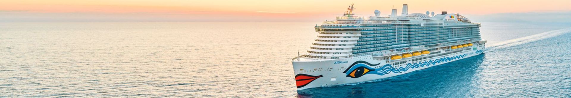 Das Kreuzfahrtschiff AIDAcosma fährt über das ruhige Meer in Richtung Sonnenuntergang, mit klar erkennbarer Bugbemalung und weitläufigen Außendecks