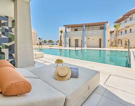 Exklusive Swim‑up‑Zimmer mit direktem Poolzugang und moderner Sonnenliege im Paralos Kosta Alimia Resort