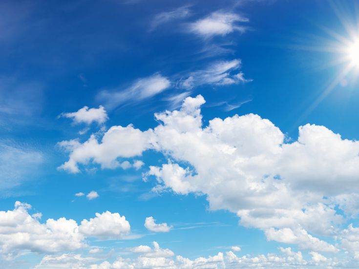 Blauer Himmel mit weißen Wolken und strahlender Sonne