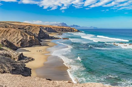 Weitläufiger Sandstrand Playa del Viejo Reyes mit hohen Klippen und türkisfarbenem Meer auf Fuerteventura