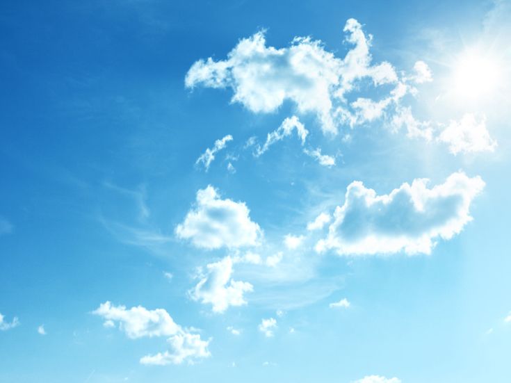 Blauer Himmel mit vereinzelten weißen Wolken und Sonnenlicht