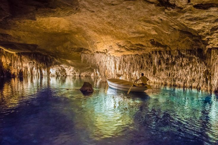 Boot fährt durch die beleuchteten Tropfsteinhöhlen Cuevas del Drach auf Mallorca