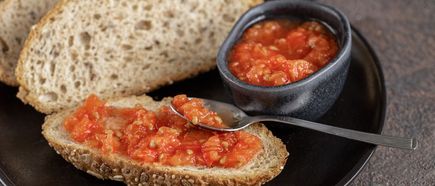 Mallorquinisches Pa amb oli: Brot mit frischen Tomaten bestrichen, daneben eine kleine Schale mit Tomatenstücken