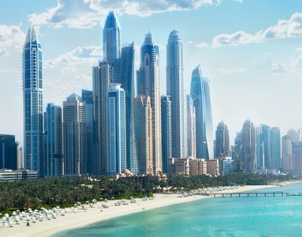 Skyline von Dubai mit hohen Wolkenkratzern am Meer unter blauem Himmel