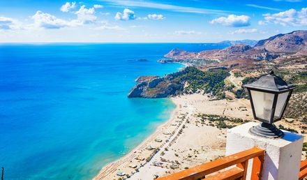 Panoramablick auf den Tsambika‑Strand auf Rhodos mit hellem Sandstrand, türkisblauem Meer und felsiger Küstenlandschaft