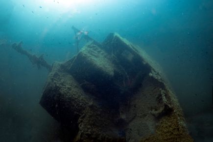 Unterwasseraufnahme eines Schiffswracks vor Palma, Mallorca. Das Wrack ist teilweise mit Algen und Sedimenten bedeckt