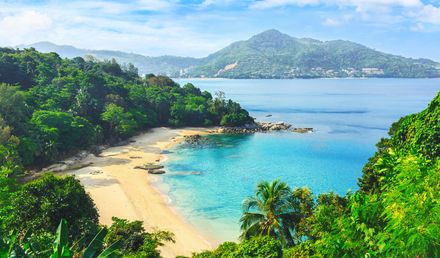 Geschwungene Bucht des Laem Sing Beach an der Andamanensee auf Phuket mit hellem Sandstrand, türkisfarbenem Wasser und dicht bewaldeten Hügeln